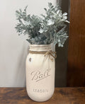 Rustic mason jar with various greenery